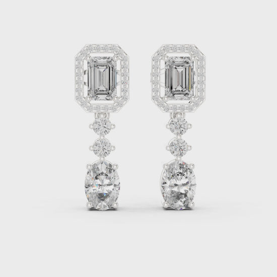 Emerald-cut drop halo dangler earrings with round diamond halo and polished metal finish