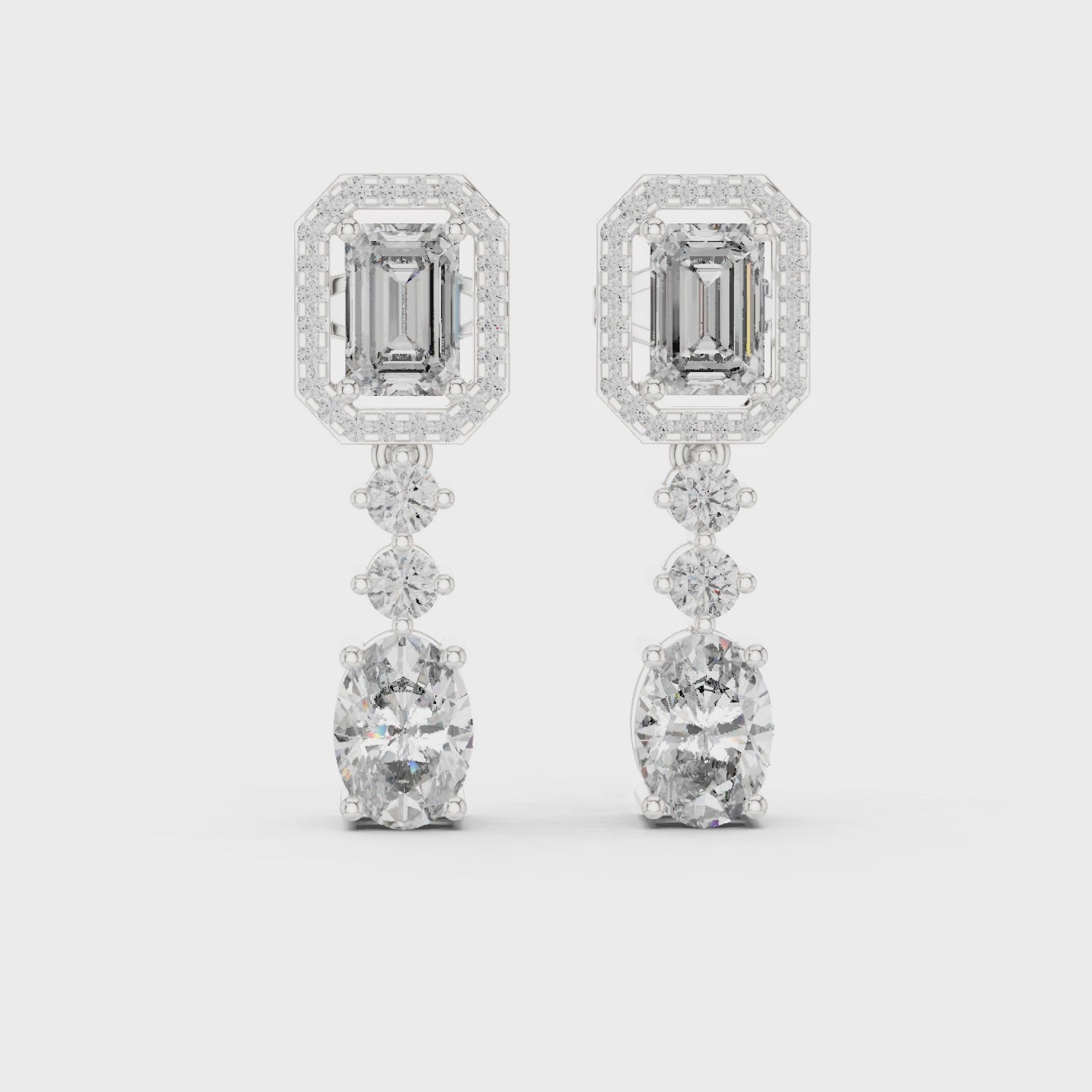 Emerald-cut drop halo dangler earrings with round diamond halo and polished metal finish