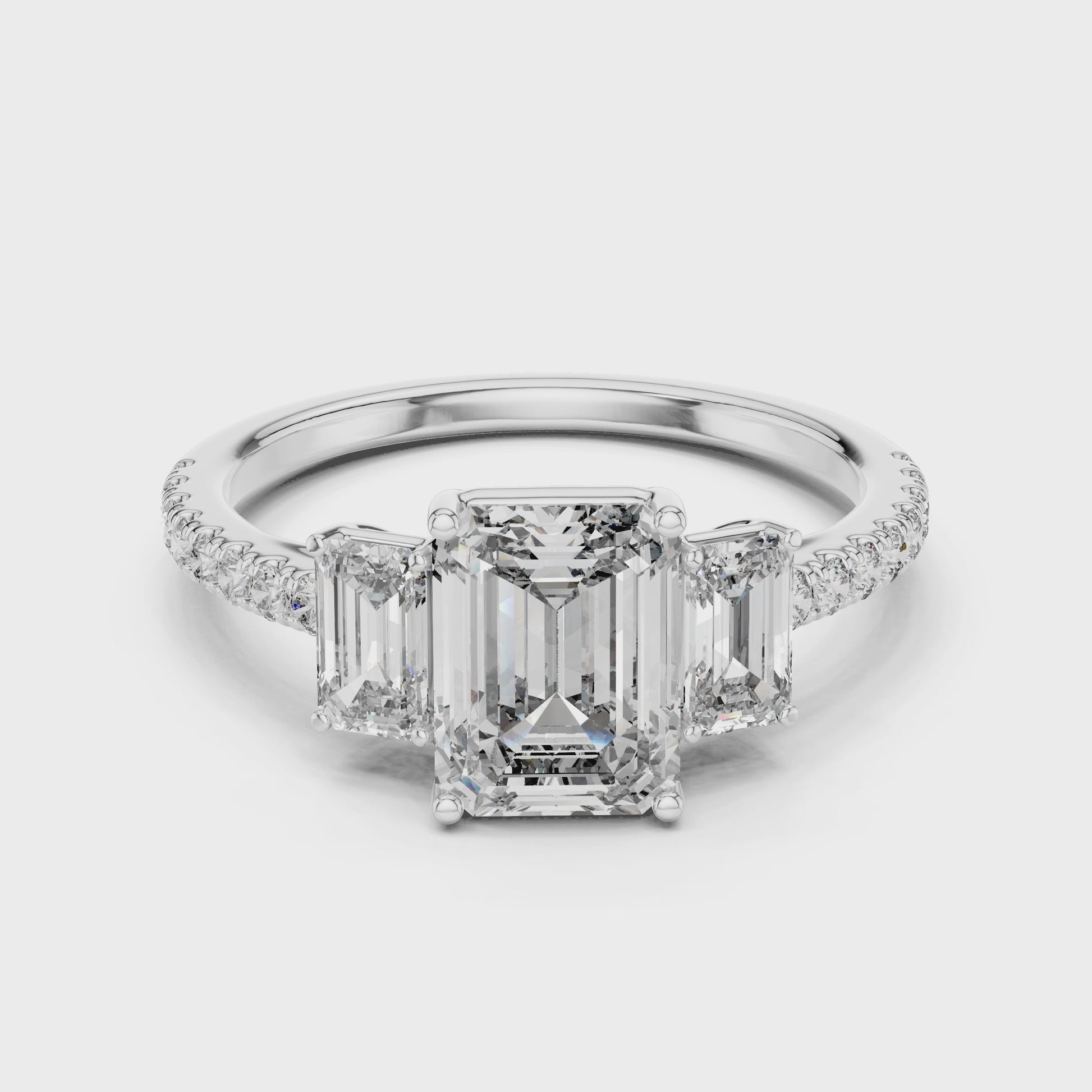 Emerald three-stone ring with diamond side stones in a classic elegant design